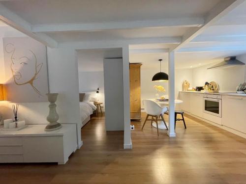 um quarto com uma cozinha e uma sala de estar com uma cama em Duinstudio Bergen em Bergen