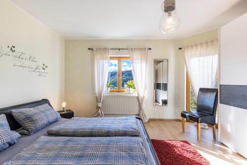 a bedroom with a bed and a chair and a window at Südalb in Albstadt