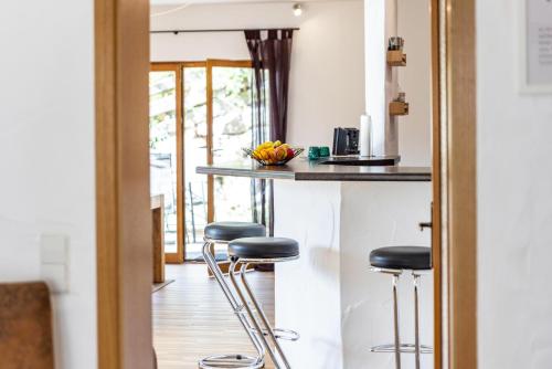 a kitchen with bar stools at a counter at Südalb in Albstadt