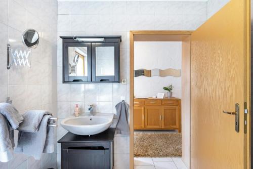 uma casa de banho com um lavatório e um espelho em Südalb em Albstadt