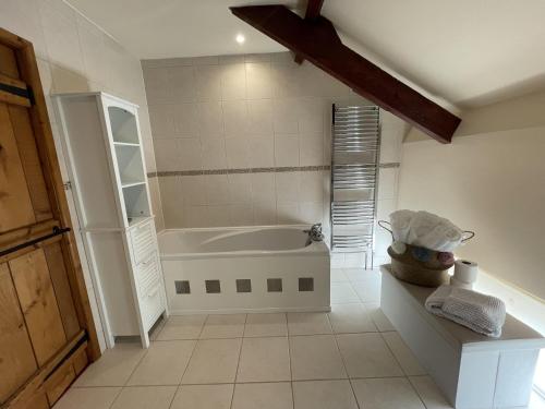 uma casa de banho com banheira num quarto em The Granary Stunning Barn Conversion em Broadwoodkelly