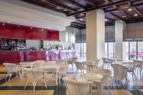 a restaurant with tables and chairs and a bar at ALEGRIA Colonial Mar Aquafun in Roquetas de Mar