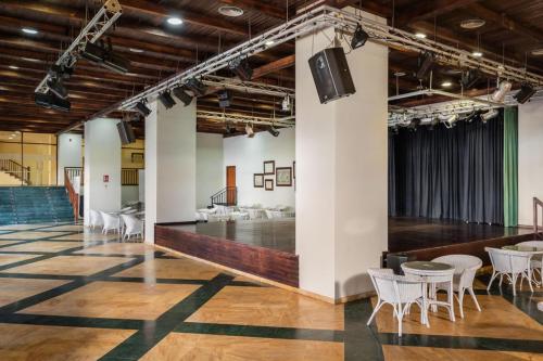 a large room with tables and chairs and a stage at ALEGRIA Colonial Mar Aquafun in Roquetas de Mar