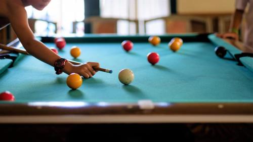 a person is playing pool on a pool table at ALEGRIA Colonial Mar Aquafun in Roquetas de Mar