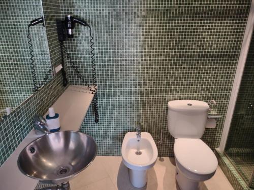 a bathroom with a toilet and a sink and a shower at By Paseo de Colón Apartment in Barcelona