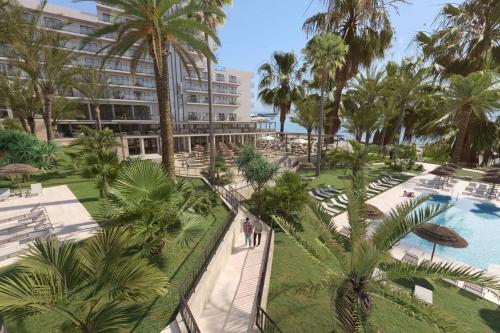 an aerial view of a resort with a pool and palm trees at Hotel Best Triton in Benalmádena