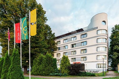 a building with two flags in front of it at Rija VEF Hotel with FREE Parking in Rīga