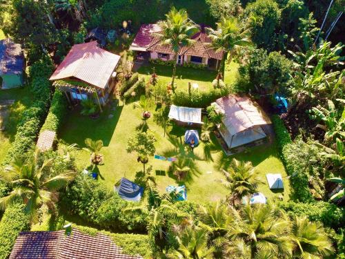 an aerial view of a house with a yard with palm trees at FLORA Praia do Sono Lodge & Trekking in Paraty