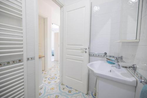 a white bathroom with a sink and a mirror at Agriturismo Le Tagliate in Uggiano la Chiesa