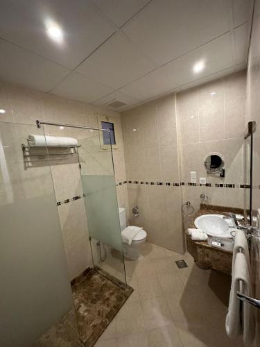 a bathroom with a shower and a toilet and a sink at Al Joud Hotel Makkah in Makkah