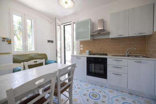 a kitchen with white cabinets and a table with chairs at Agriturismo Le Tagliate in Uggiano la Chiesa