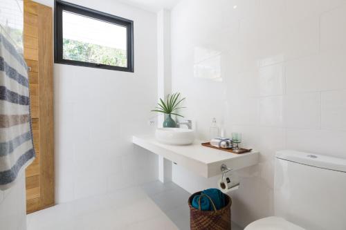 baño blanco con lavabo y ventana en Lavaliere by NB Villas en Koh Samui