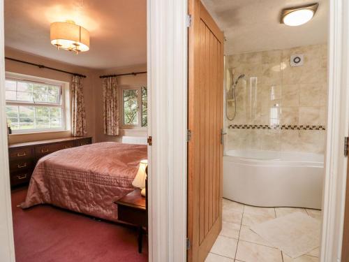 a bedroom with a bed and a bath tub at Thwaite How in Keswick