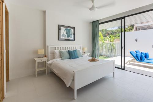 Habitación blanca con cama y balcón. en Lavaliere by NB Villas en Koh Samui