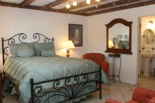 a bedroom with a bed and a mirror and a chair at Chantico Inn in Ojai
