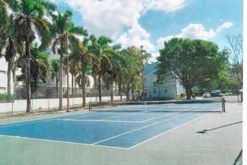 a tennis court with palm trees on it at Paradise Point Villa Negril in Orange Bay