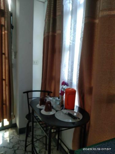 a small table with food on it next to a window at De Hagan Transient Baguio City in Baguio
