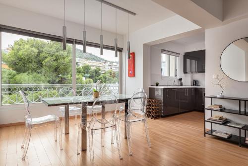 a kitchen and dining room with a table and chairs at Athenian Riviera Executive Apartment in Vari