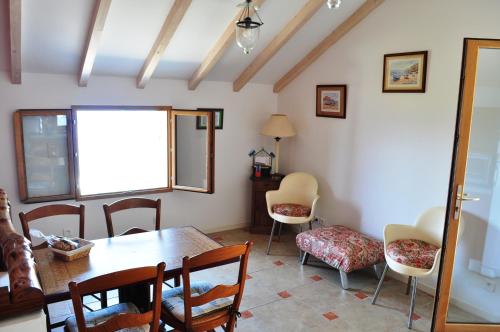 a dining room with a table and chairs and a window at CABANON TIMANTHE in Canari