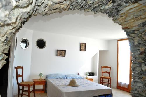 a bedroom with a bed with a stone wall at CABANON TIMANTHE in Canari