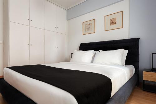- une chambre avec un grand lit noir et blanc dans l'établissement Athenian Riviera Executive Apartment, à Vari