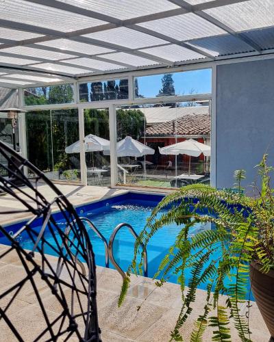 a house with a swimming pool with a ceiling at Posada Mia Nonna in Villa General Belgrano