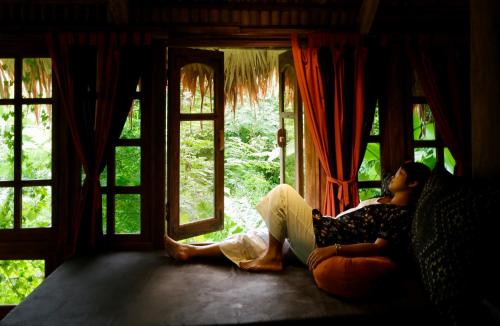 a woman sitting on a couch looking out of a window at Lua Pu Luong in Pu Luong
