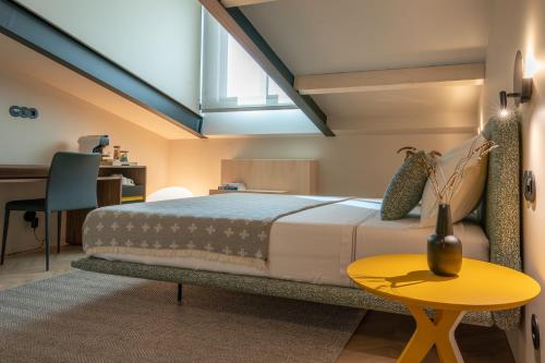 a bedroom with a large bed and a desk at SUTRooms in Braga