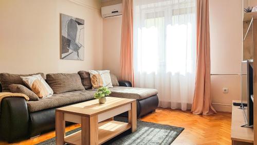 uma sala de estar com um sofá e uma mesa de centro em FilinHome Jaksica Suite em Novi Sad