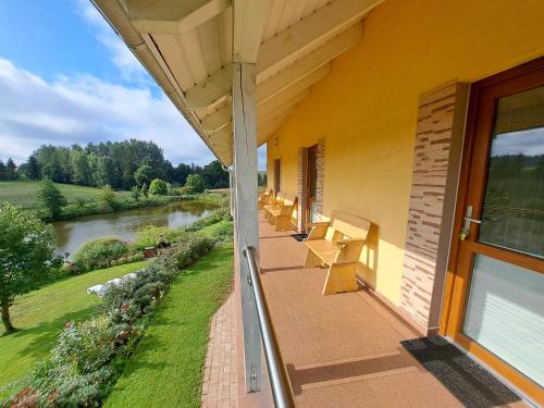 a porch of a building with a view of a river at Dolina Miodu - Kaszuby, Sauna, Gorąca Balia in Borowina