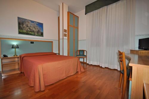 ポルト・トッレスにあるHotel Elisaのベッドとテレビが備わるホテルルームです。