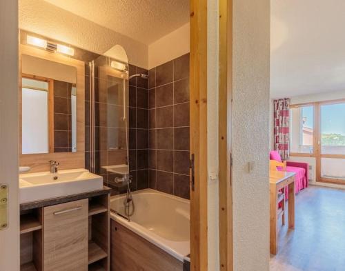 une salle de bain avec une baignoire et un lavabo dans l'établissement Bel appartement vue montagne, à La Plagne Tarentaise