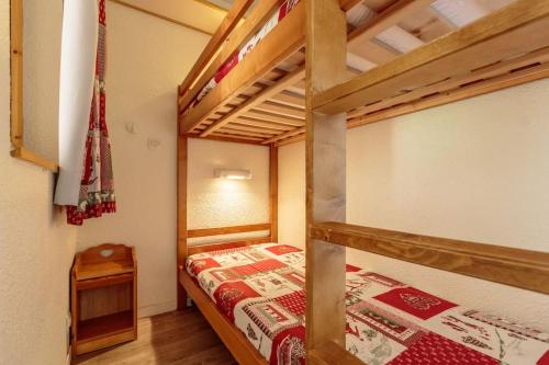 une chambre avec deux lits superposés et une table dans l'établissement Bel appartement vue montagne, à La Plagne Tarentaise