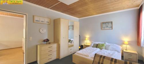 a bedroom with a bed and a dresser and a mirror at Apartment Almkogel by FiS - Fun in Styria in Tauplitz