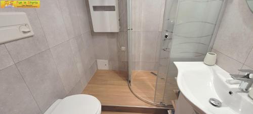 a bathroom with a shower and a toilet and a sink at Apartment Almkogel by FiS - Fun in Styria in Tauplitz
