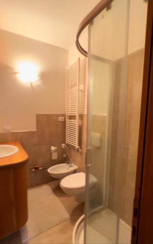 La salle de bains est pourvue de toilettes, d'un lavabo et d'une douche. dans l'établissement Nel cuore di Pila, à Pila