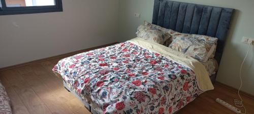 uma cama com um cobertor florido e almofadas em room in Residence Lilya fermée et sécurisée em Casablanca