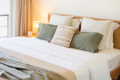 a large white bed with pillows on it at Magníficos Dias Atlânticos in Moledo