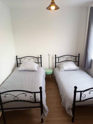 two beds sitting next to each other in a room at Maison charmante à Cayeux-sur-Mer avec jardin privatif in Cayeux-sur-Mer