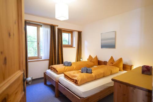 um quarto com 2 camas com lençóis amarelos em Chasa Val 735c em Scuol
