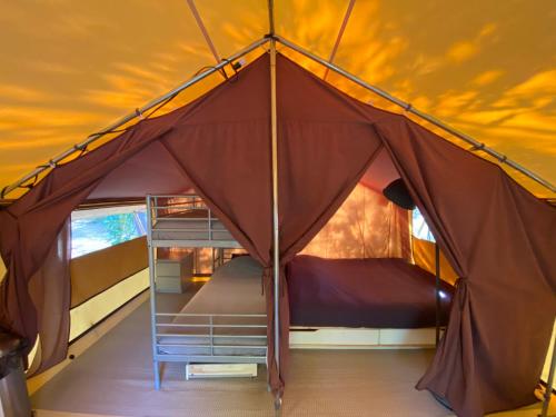 Cette grande tente comprend des lits superposés. dans l'établissement Camping la Kahute, tente lodge au coeur de la forêt, à Carcans