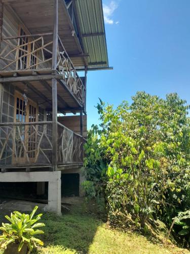 a house with a balcony on the side of it at Cabanas Armonia in Cotundo