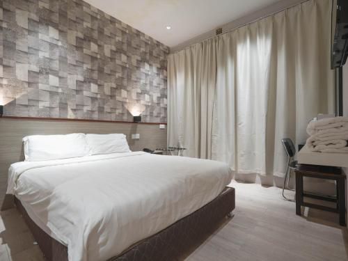 um quarto com uma grande cama branca e uma secretária em Noble Hotel Express, Check in 10PM, Check out 9AM em Singapura