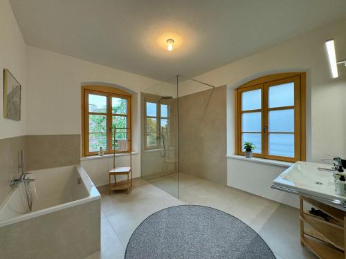 a bathroom with a tub and a shower and a sink at Ferienzauber 1897 in Dornbirn