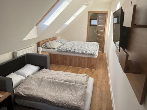 Duas camas num pequeno quarto com uma escada em Reštaurácia Koliba em Hnúšťa