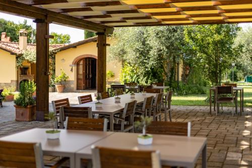 a row of tables and chairs under a pergola at Agriturismo LaPievuccia in Castiglion Fiorentino
