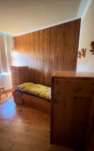 a bedroom with a bed and a wooden wall at Nel cuore di Pila in Pila
