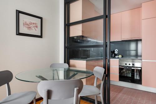 a dining room with a glass table and chairs at Rivoli Apartments in Porto