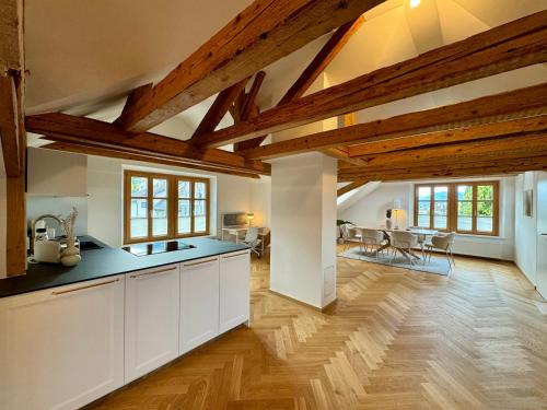 an open kitchen with wooden ceilings and wooden floors at Ferienzauber 1897 in Dornbirn