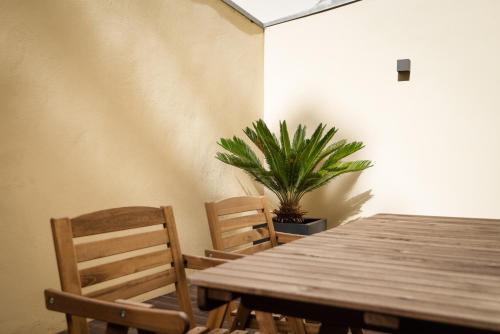 a wooden table with two chairs and a potted plant at Rivoli Apartments in Porto